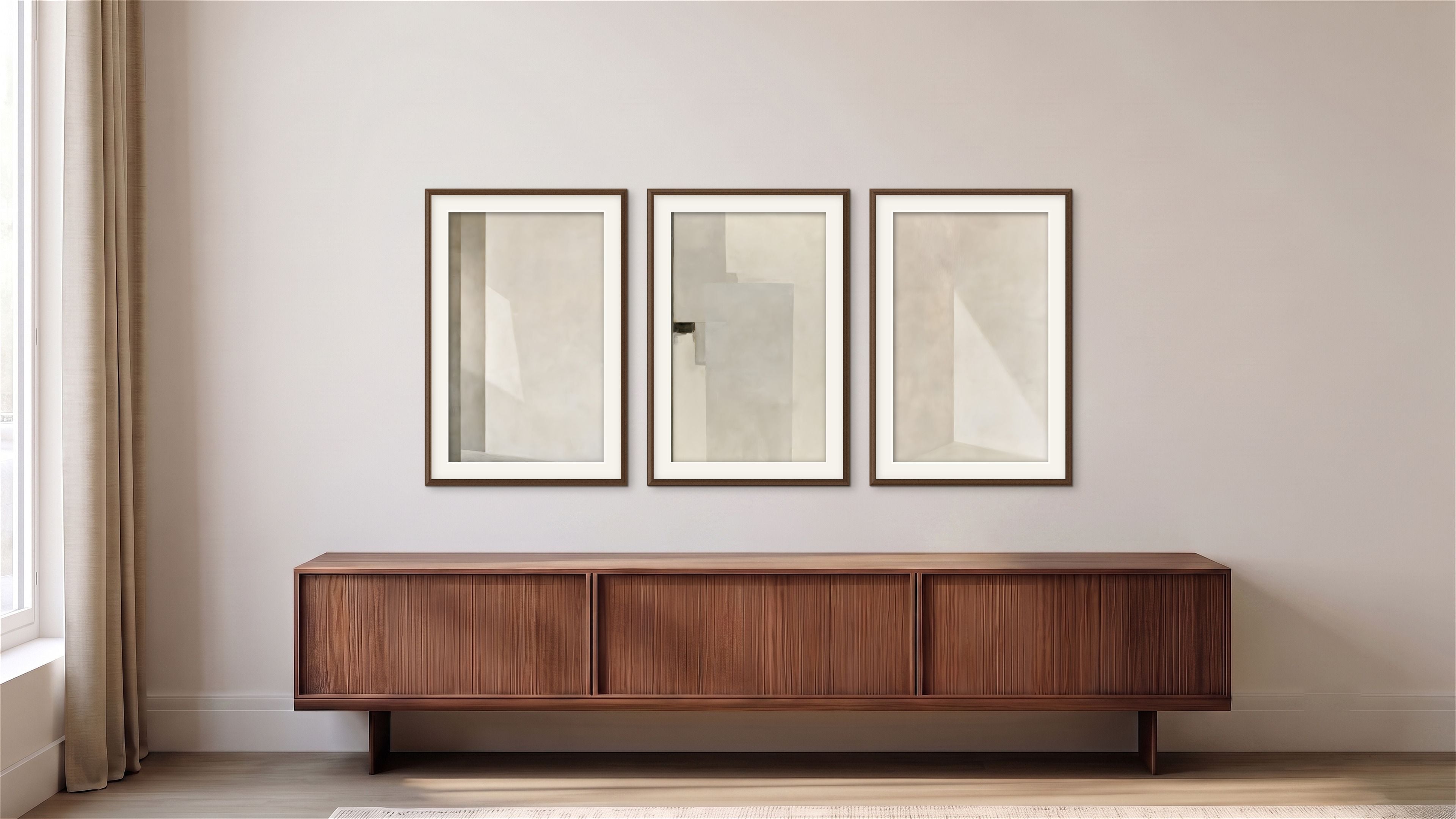 Three Quiet Intersections abstract artworks in soft cream, ivory, and pale gray displayed above a long wood credenza in a warm minimalist interior.